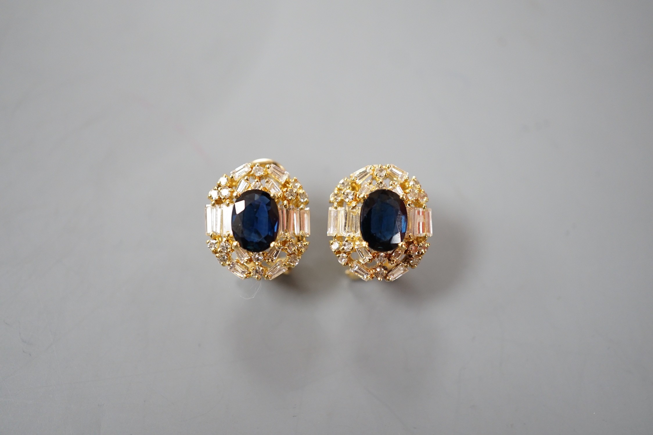 A pair of modern 750 yellow metal, sapphire and diamond set oval cluster earrings, 16mm, gross weight 8.2 grams.